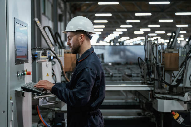 CNC operator working with precision machinery in an industrial factory environment